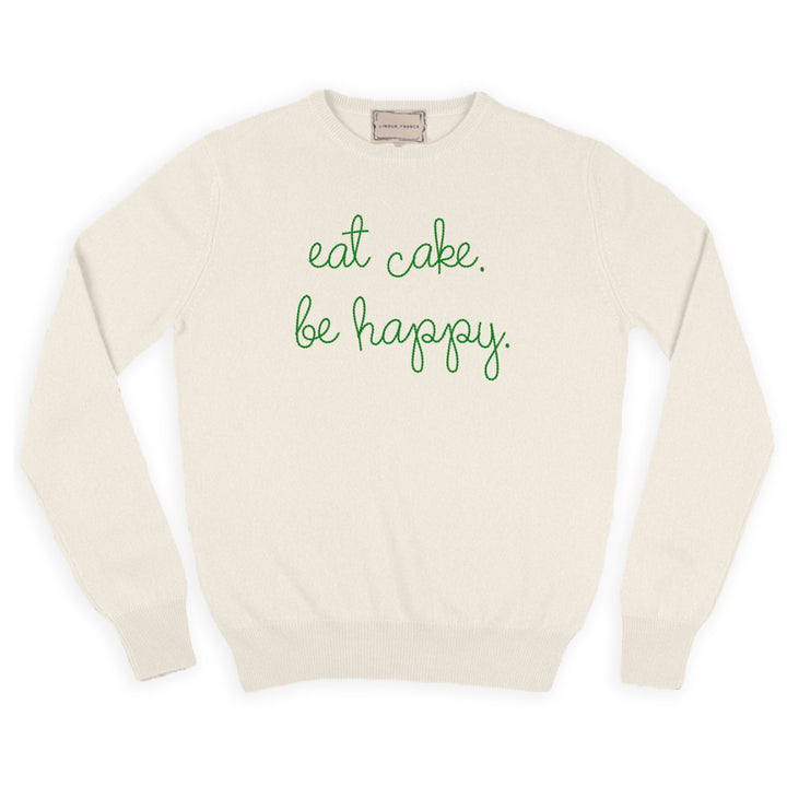 A cream cashmere sweater chain-stitched in green with the words eat cake. be happy.