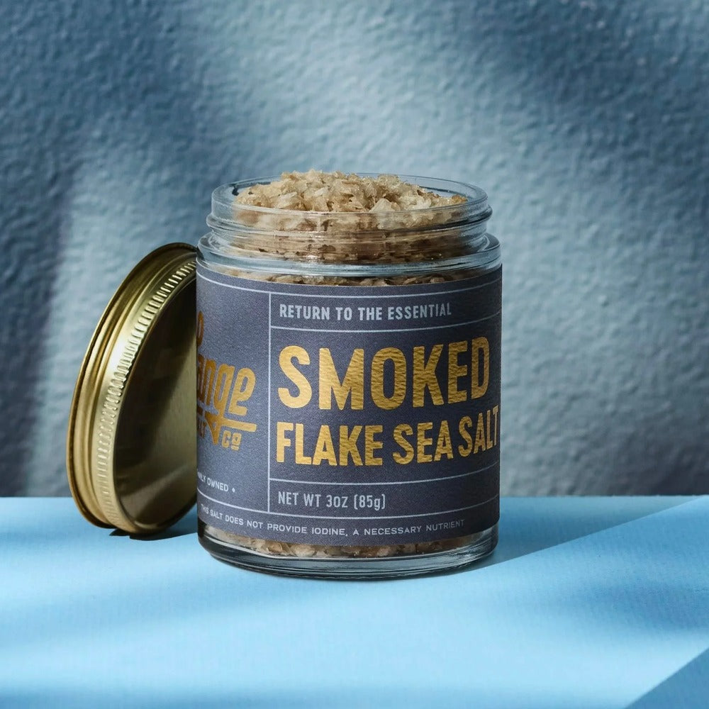 Lange Salt Co Smoked Flake Sea Salt in a 3 oz glass jar with the gold lid resting alongside